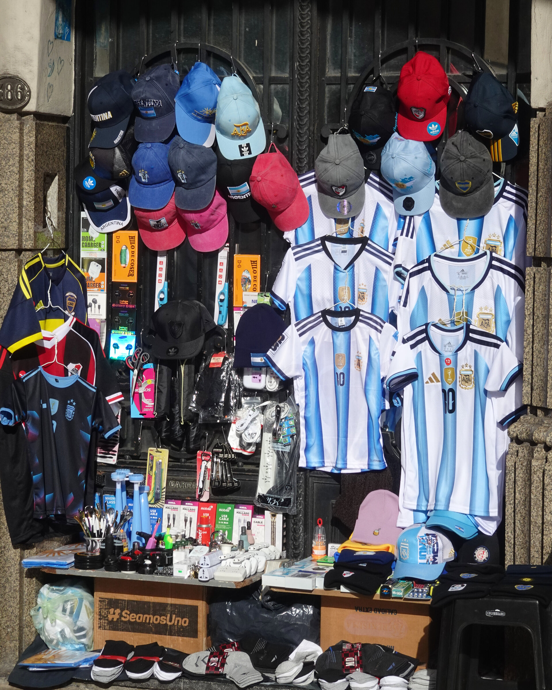 A street stall hung with football shirts, caps and phone accessories