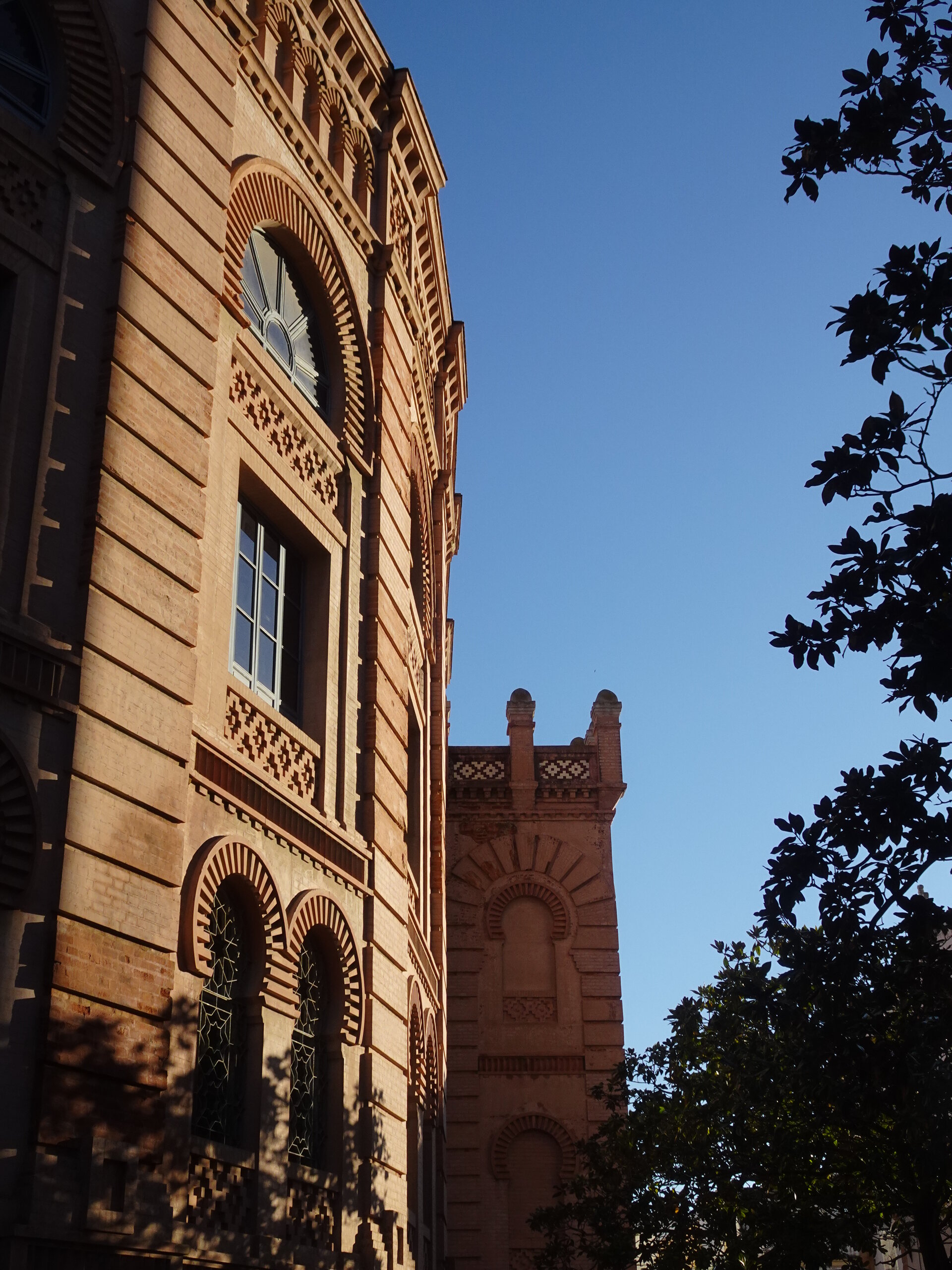 Ornate Moorish-style building with arched windows at sunset