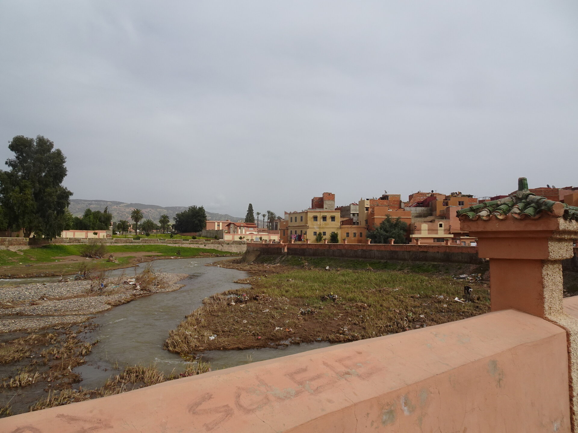 River flowing past a town with colourful buildings from a bridge