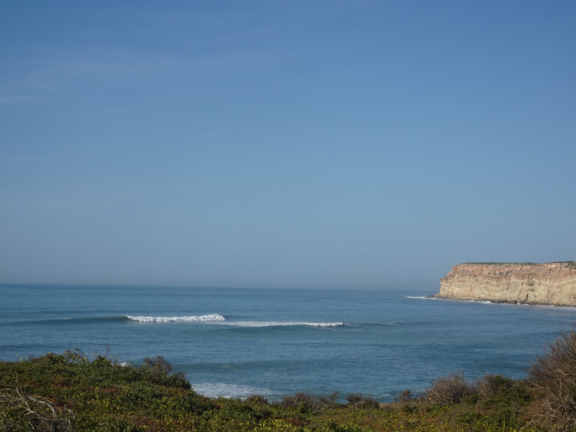 Coastal view with waves breaking near sandstone cliffs