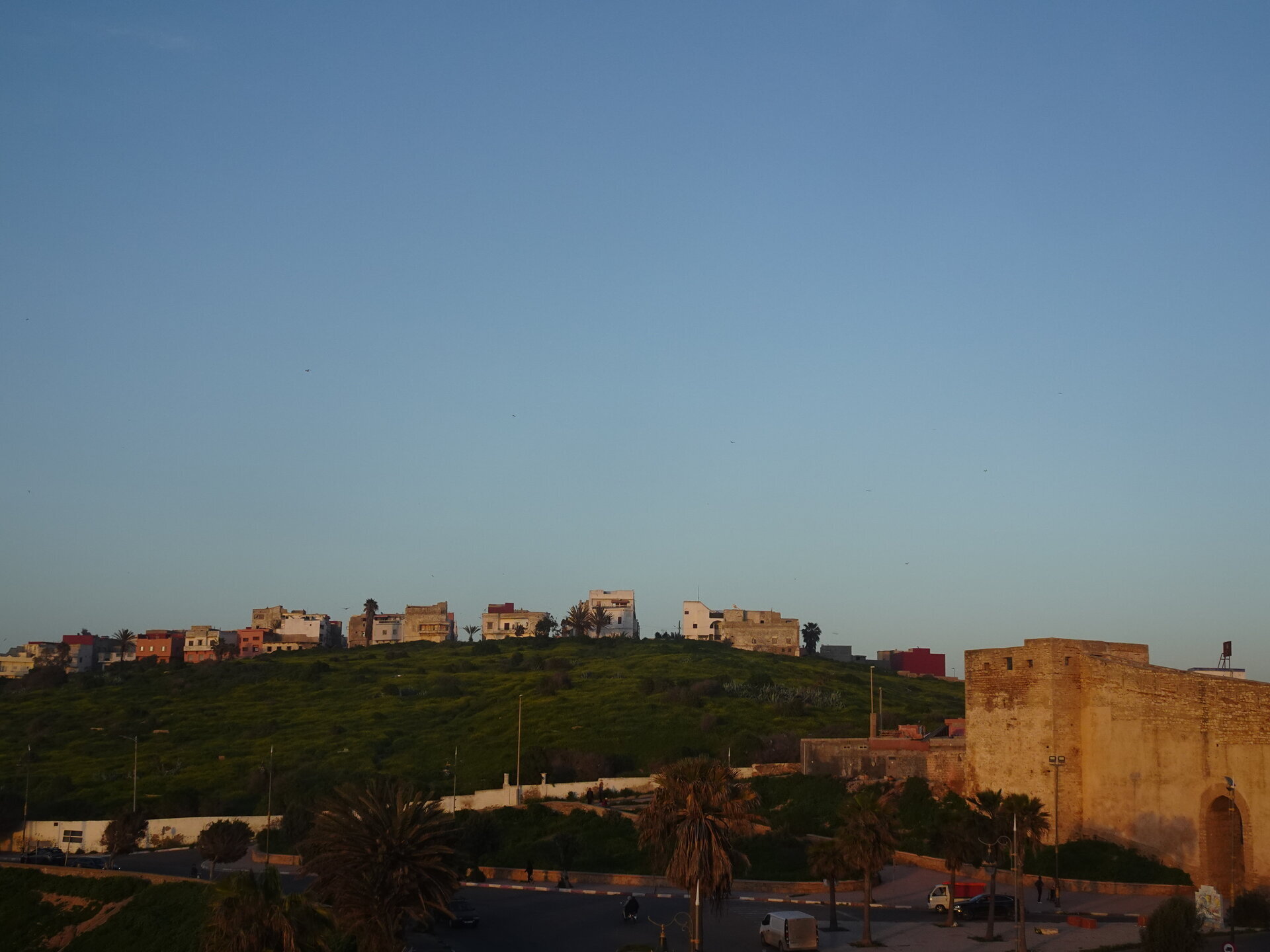 Hilltop town with colourful buildings and old fortification walls in golden hour light